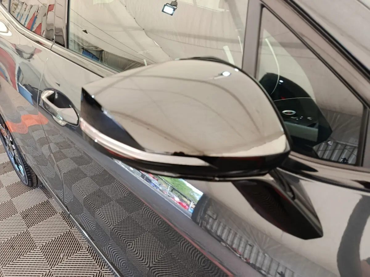 Rétroviseur côté gauche gris foncé du Kia Sportage 2026, avec clignotant intégré et carrosserie brillante.