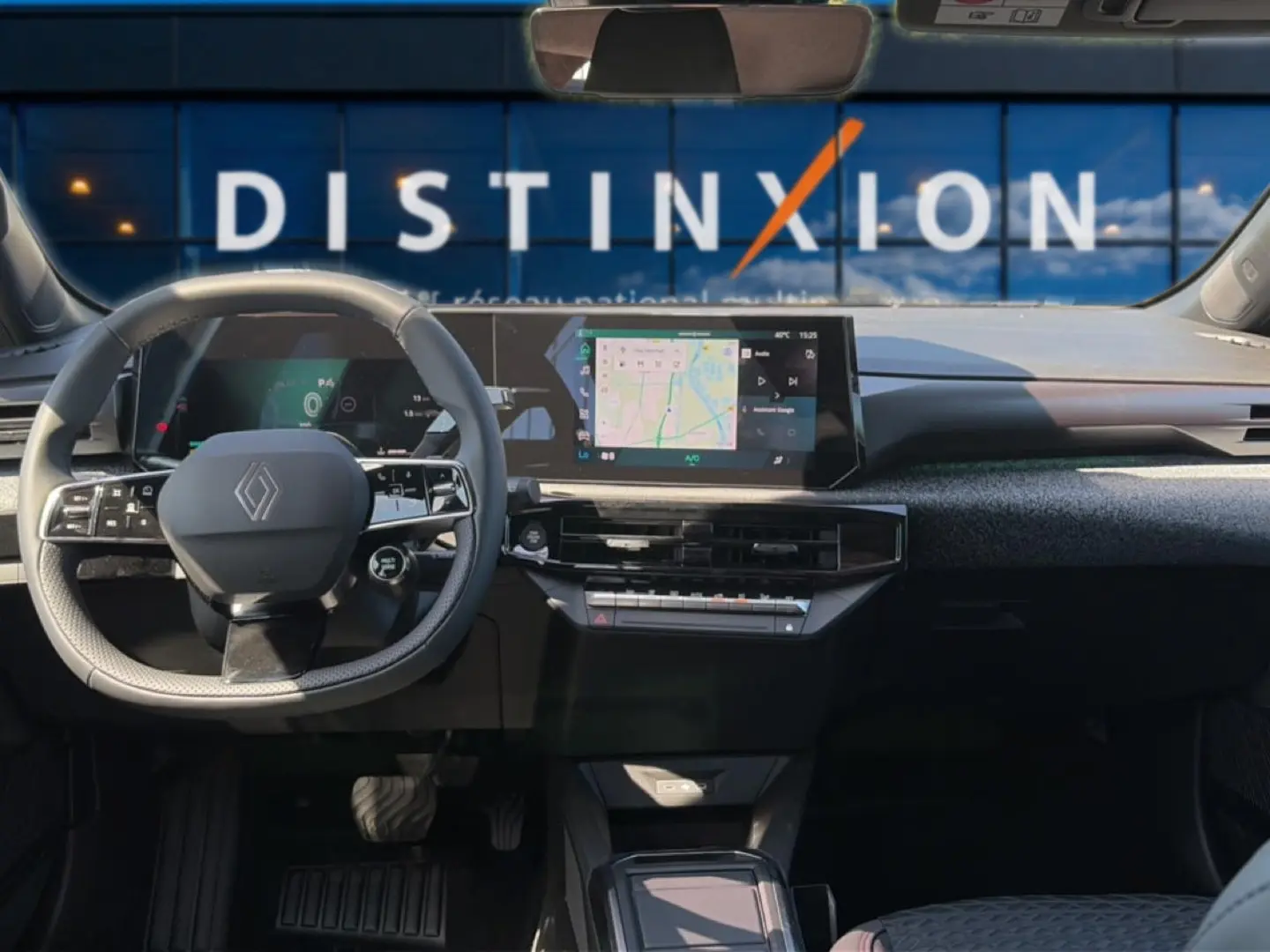 Vue intérieure avant de la Renault Clio VI noire, avec tableau de bord numérique et écran tactile central affichant la navigation.