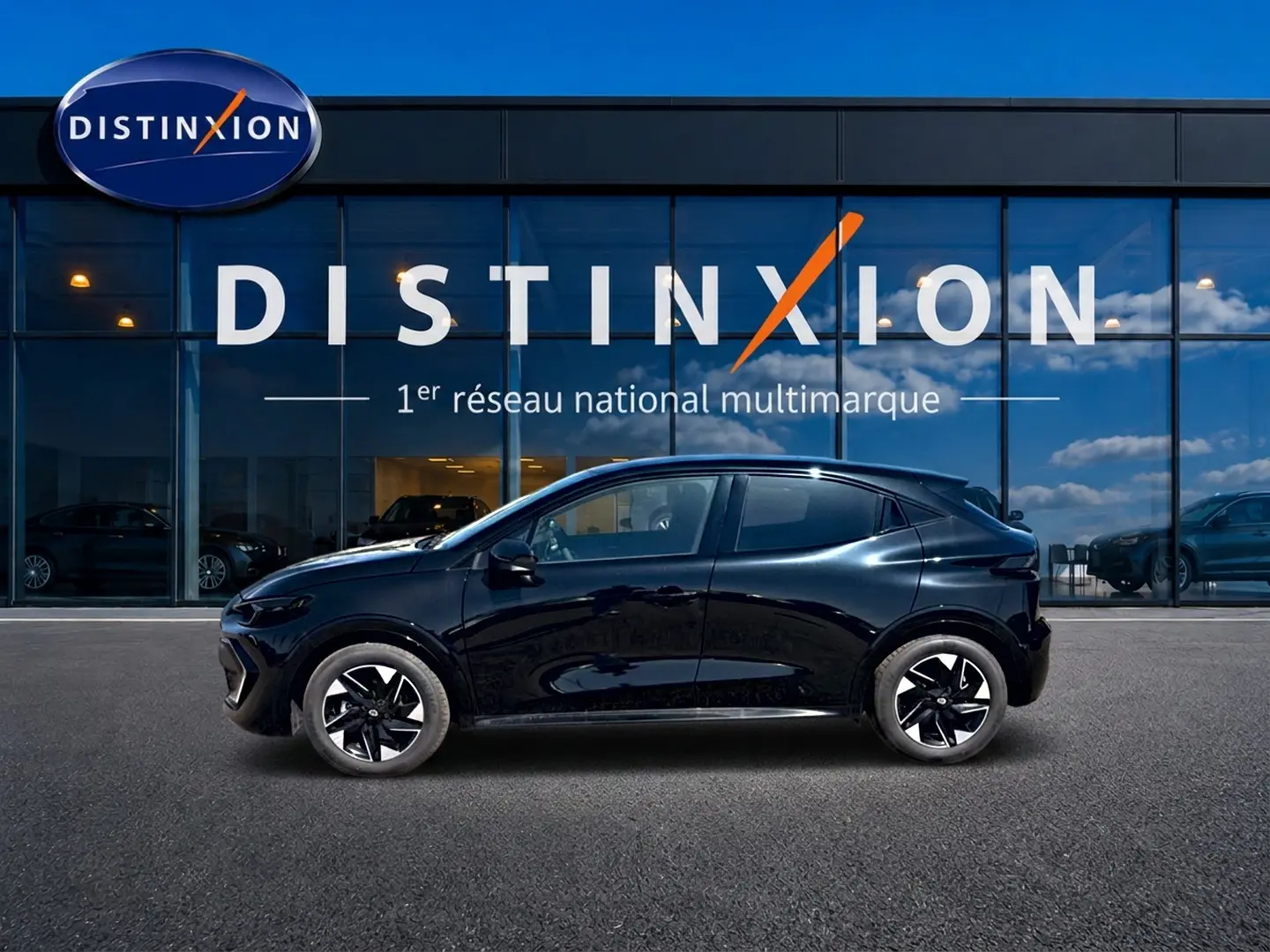 Renault Clio VI noire vue de profil côté gauche, avec jantes alliage et silhouette compacte devant une vitrine Distinxion.