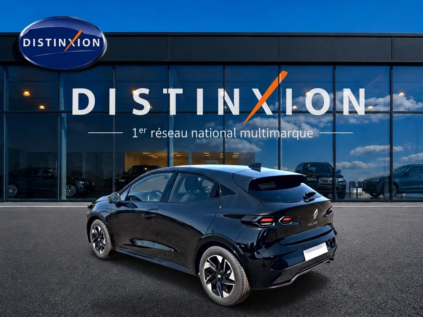 Vue 3/4 arrière droite d'une Renault Clio VI noire stationnée devant une vitrine avec logo Distinxion.