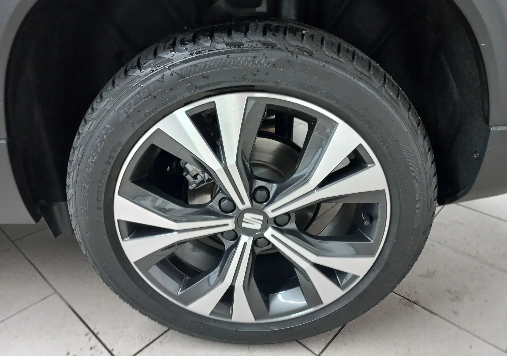 Gros plan sur la jante alliage 18'' usinée du SEAT Ateca noir Magic Nacré, mettant en valeur son design moderne.