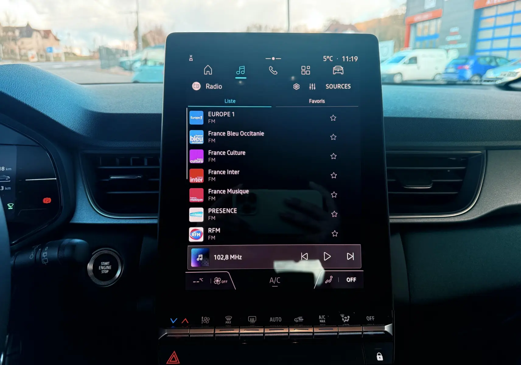 Écran tactile central du tableau de bord du Renault Captur E-Tech Hybrid 2025, affichant les stations radio FM.