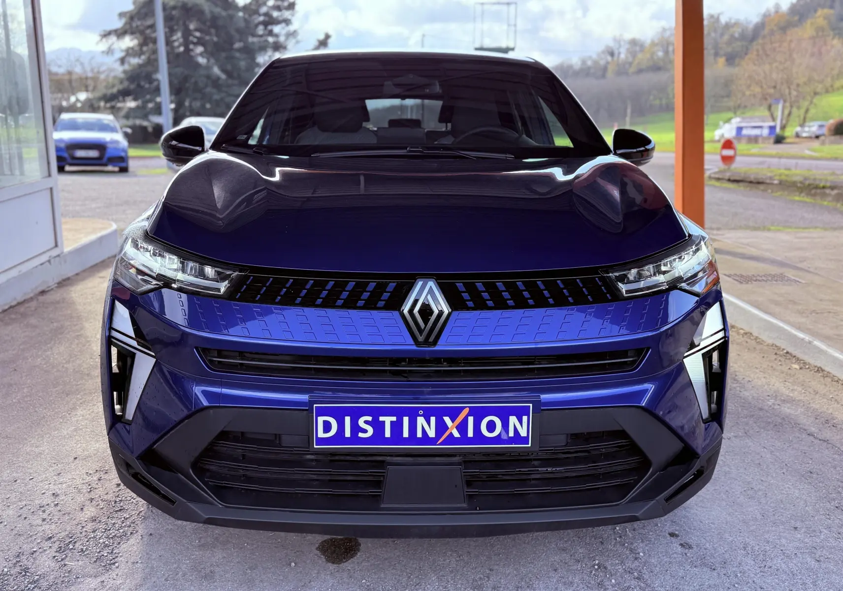 Vue frontale du Renault Captur E-Tech hybride 2025 en bleu Iron Metal avec toit noir et calandre moderne.