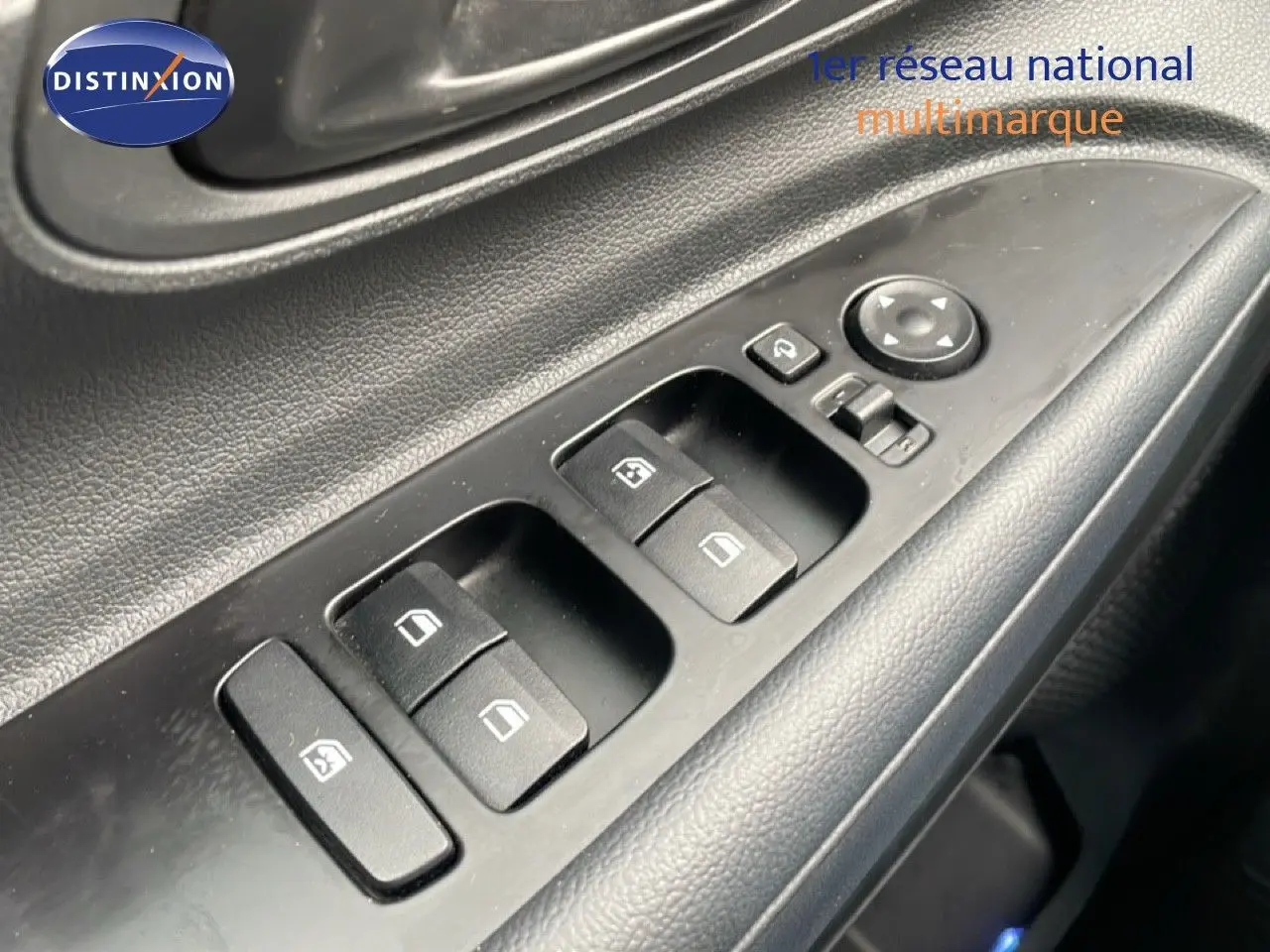 Gros plan sur les commandes des vitres électriques côté conducteur d'une Hyundai i20 noire Phantom Metal 2025.