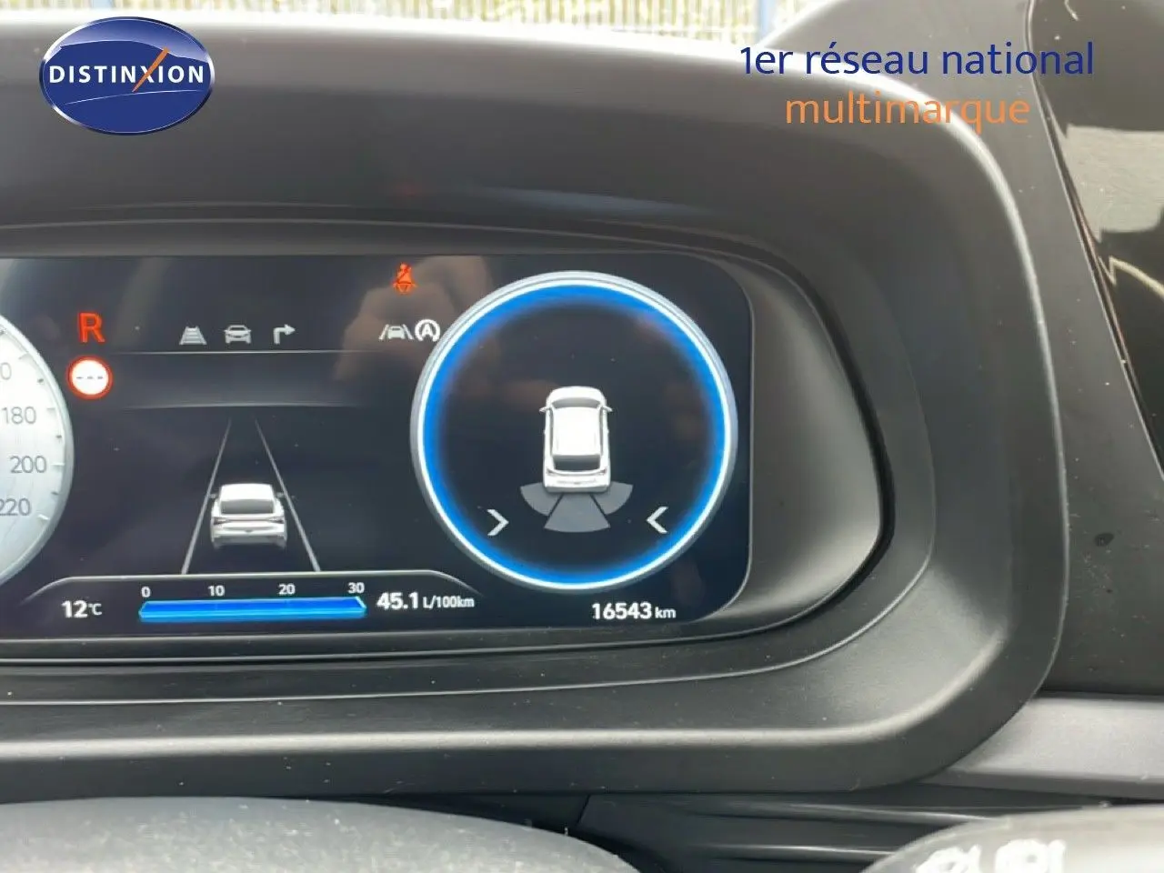 Tableau de bord numérique du Hyundai i20 noir Phantom Metal 2025, affichant la consommation et l'aide au stationnement.