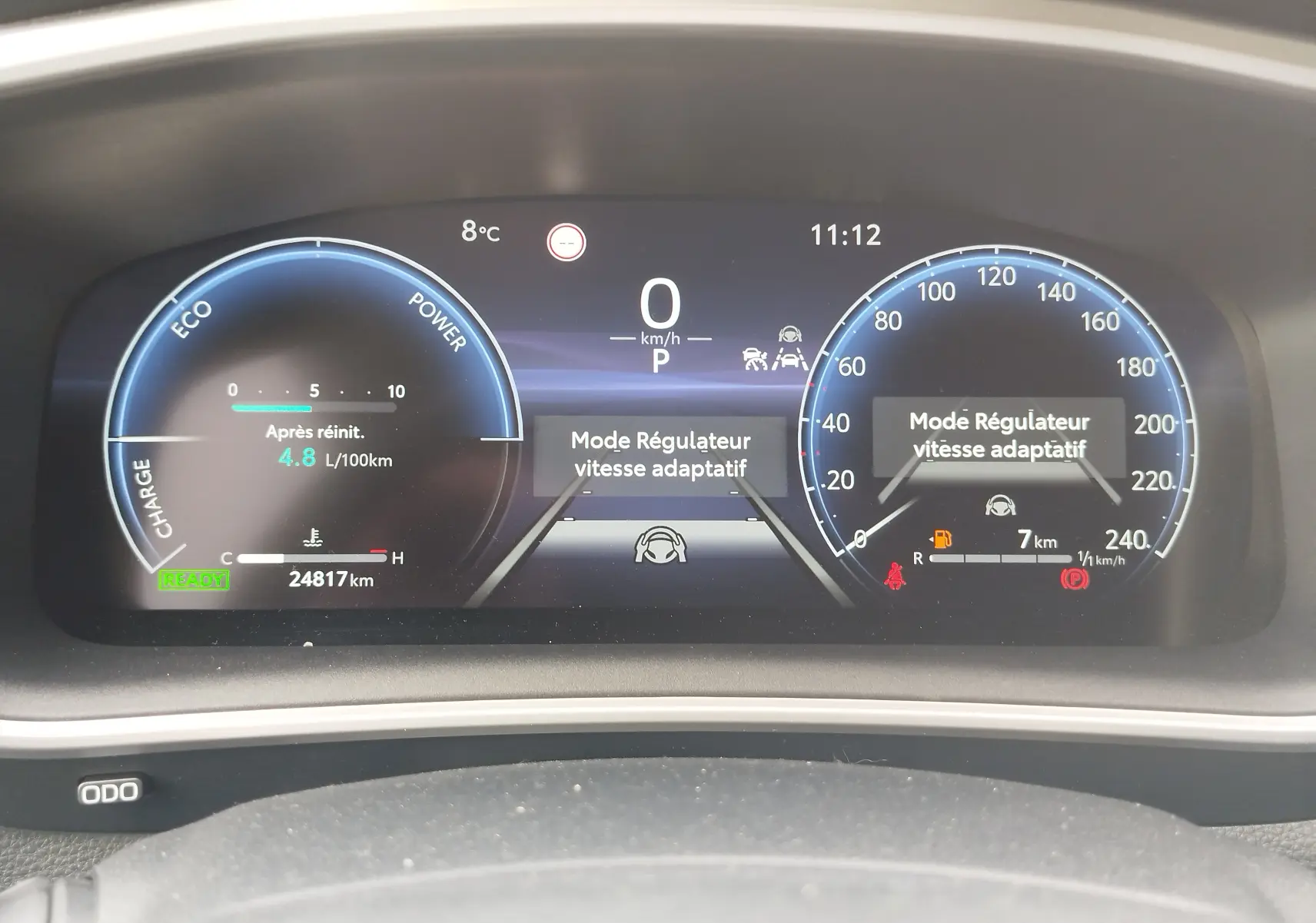 Tableau de bord numérique de Toyota Corolla Cross 2024 affichant la consommation, la vitesse à 0 km/h et le mode régulateur adaptatif.