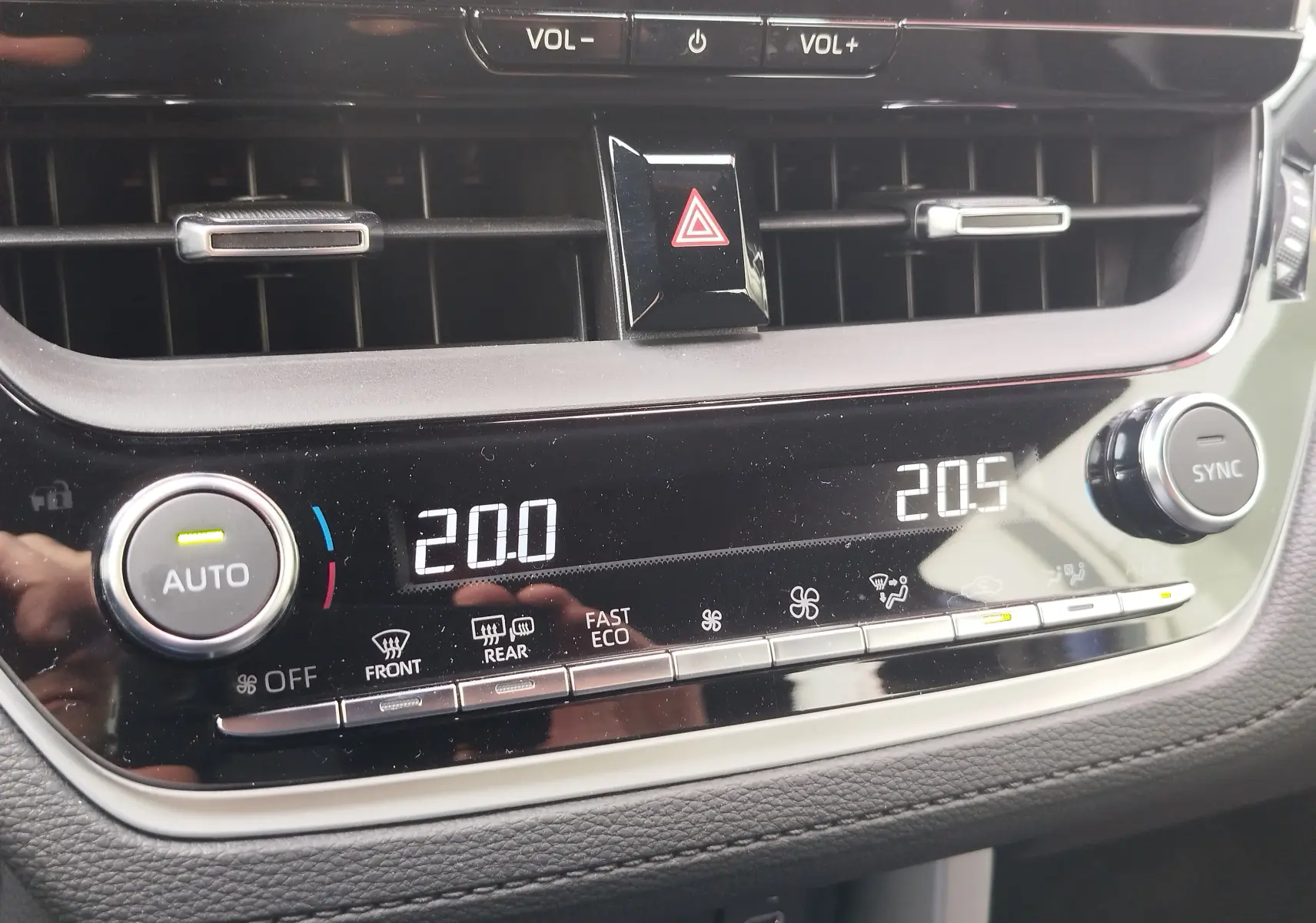 Détail du tableau de bord de la Toyota Corolla Cross 2024, affichage numérique de la climatisation avec réglages à 20°C.