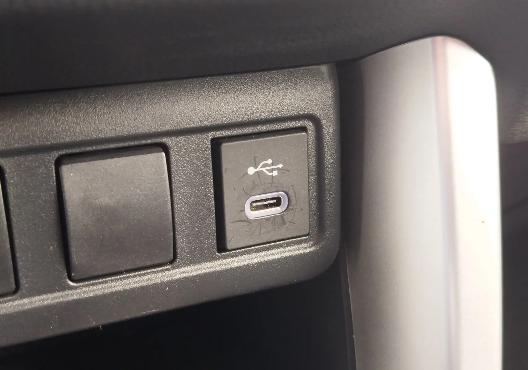 Gros plan sur un port USB-C intégré dans la console intérieure du Toyota Corolla Cross 2024 bleu cosmique.
