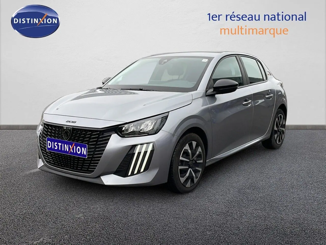 Peugeot 208 gris Artense métal vue 3/4 avant droit, avec calandre noire et feux LED verticaux distinctifs.