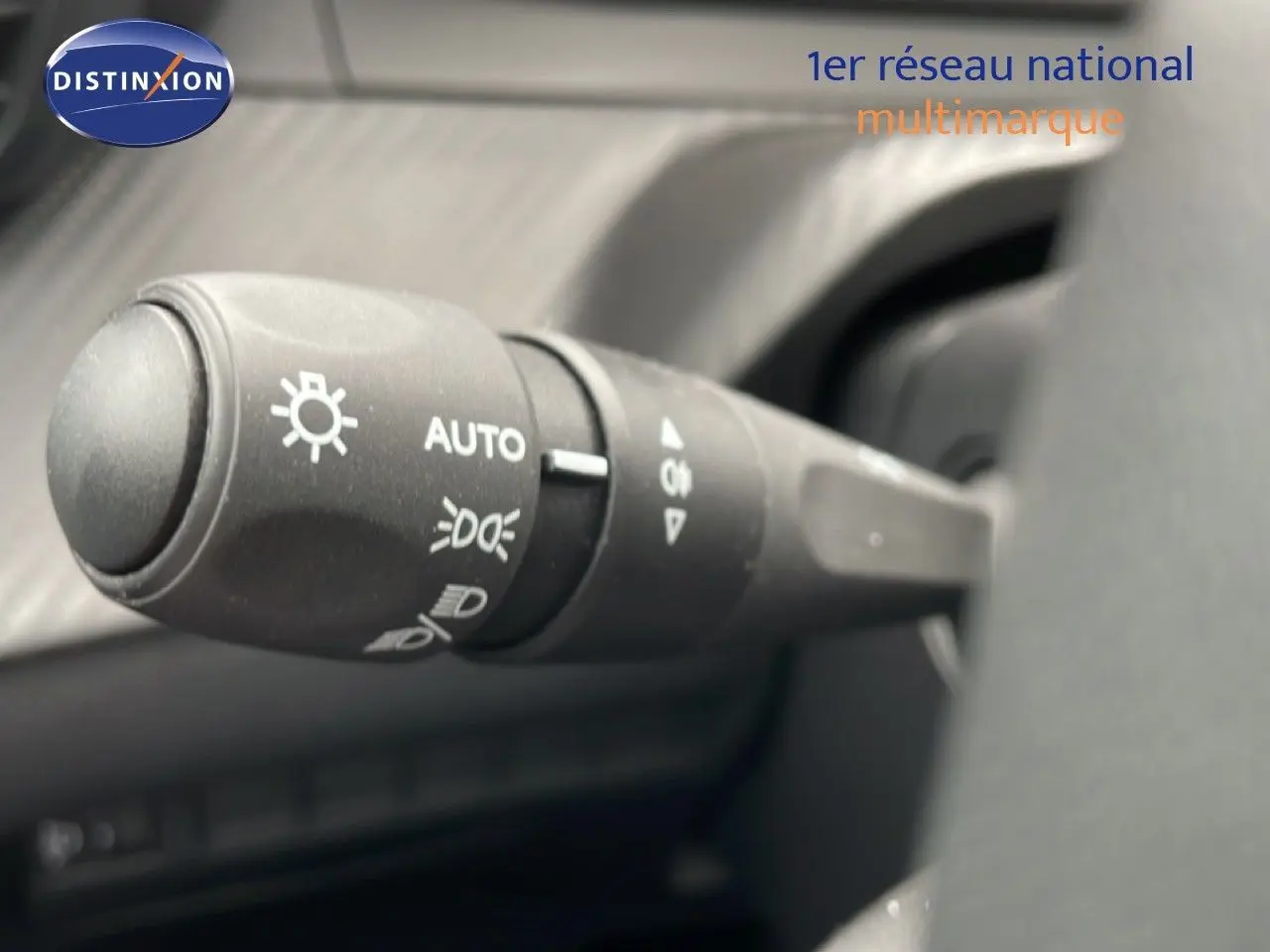 Gros plan sur la commande des feux au volant d’une Peugeot 208 gris Artense, version 2025, intérieur noir.
