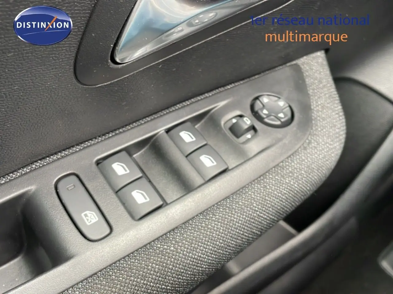 Détail des commandes des vitres électriques et rétroviseurs sur la porte côté conducteur d’une Peugeot 208 gris Artense.