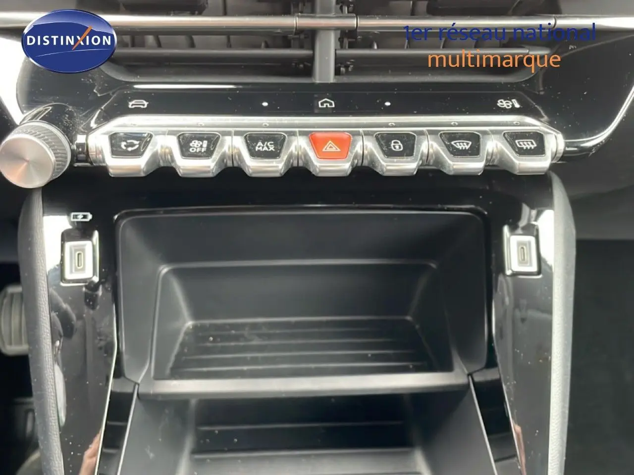 Vue rapprochée de la console centrale de la Peugeot 208 2025 gris Artense, avec boutons de commande et ports USB visibles.