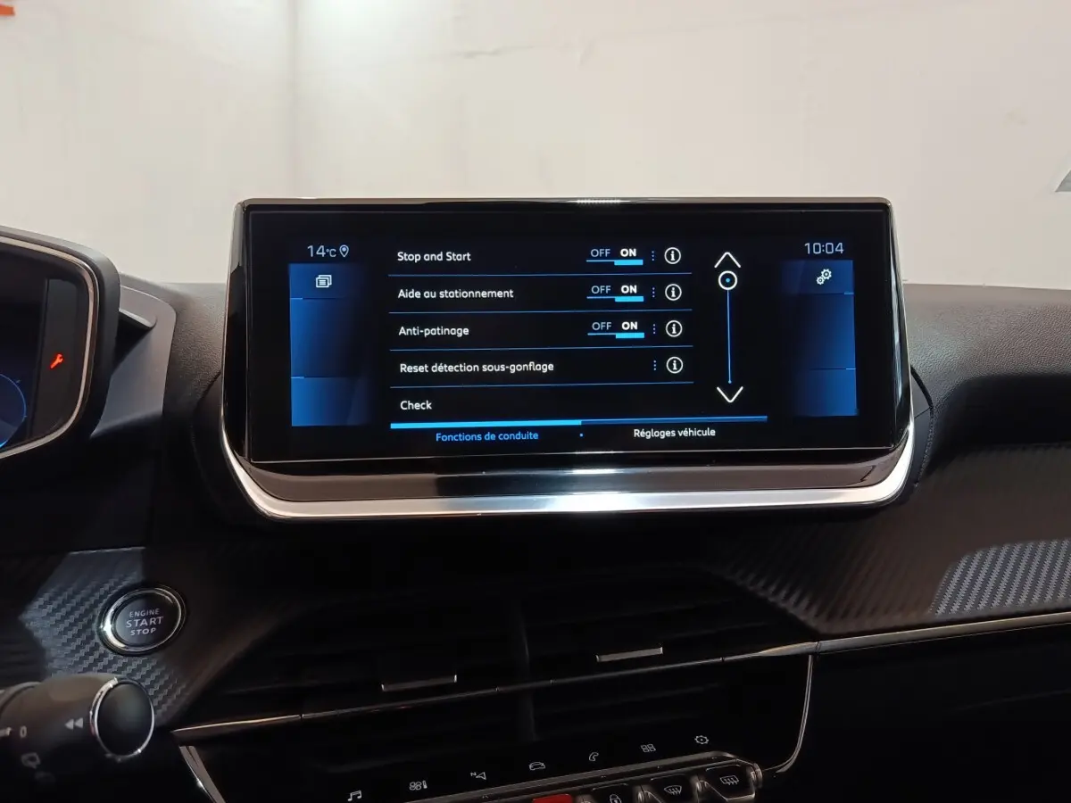 Écran tactile central de 10 pouces affichant les réglages d’aide à la conduite dans l’habitacle d’une Peugeot 208 blanche.