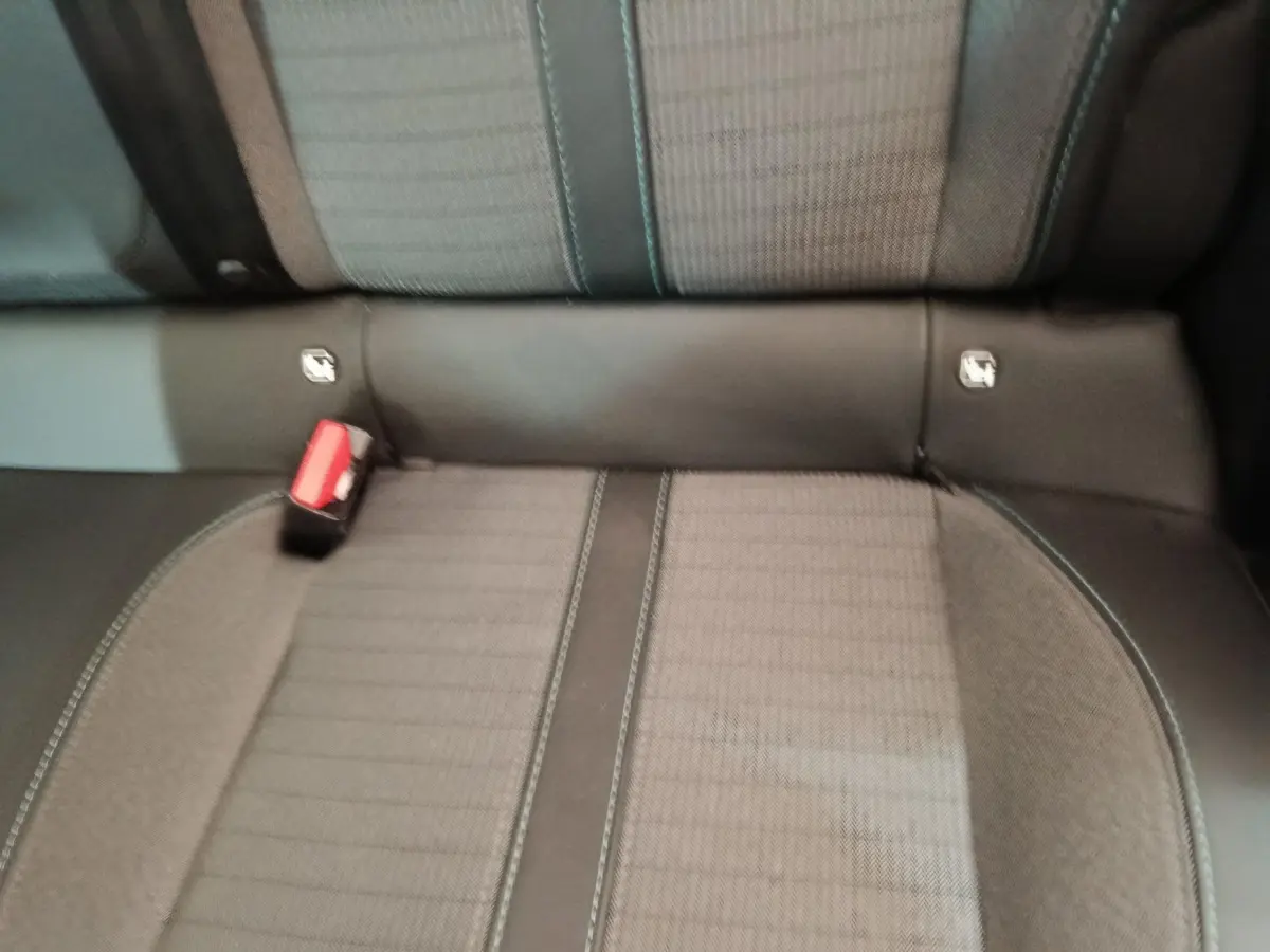 Gros plan sur la banquette arrière grise avec ceinture rouge et fixation Isofix d'une Peugeot 208 PureTech 100 S&S Allure Business.