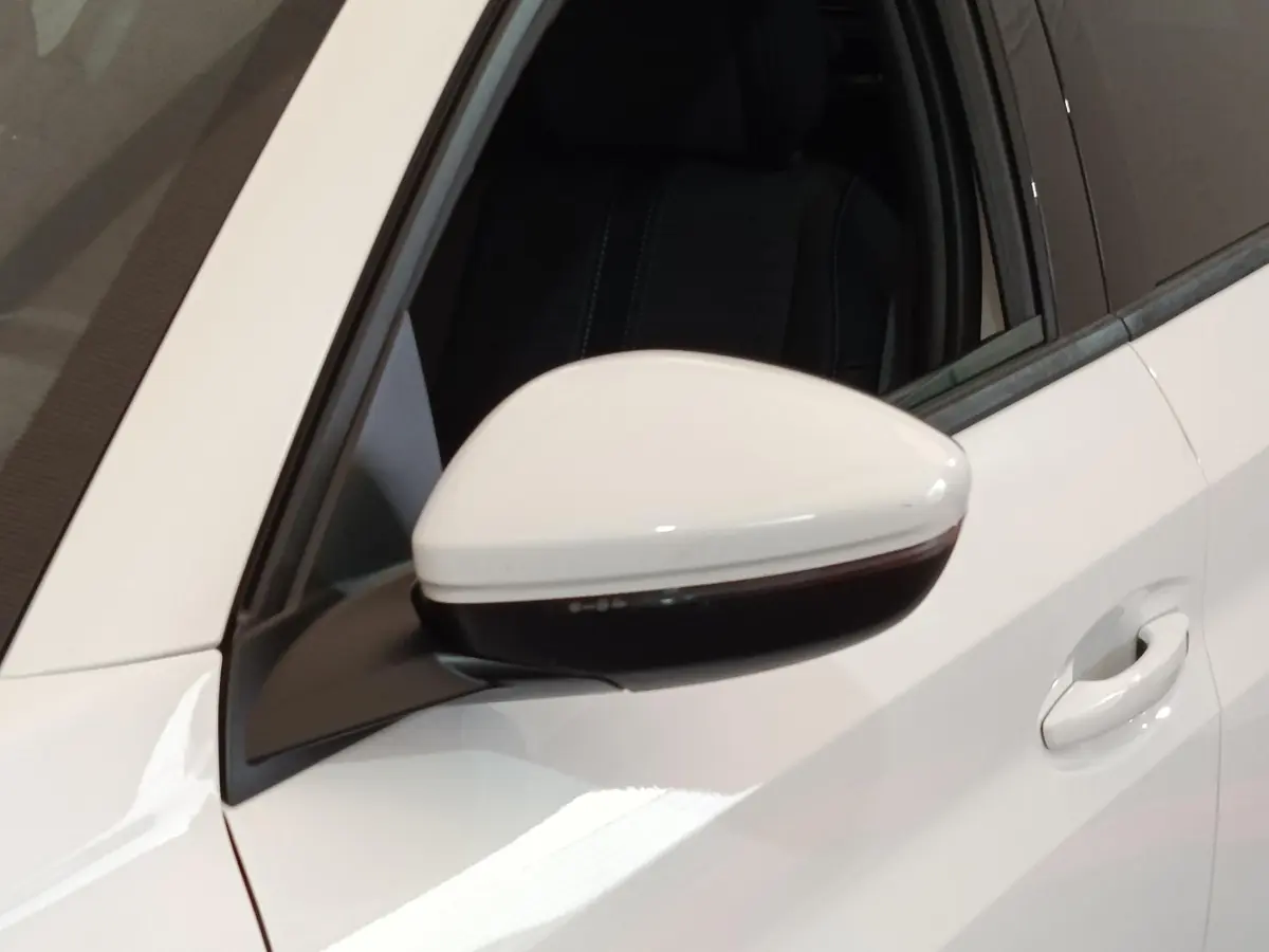 Rétroviseur côté gauche blanc de Peugeot 208 PureTech 100 S&S Allure Business 2021 avec poignée de porte assortie.