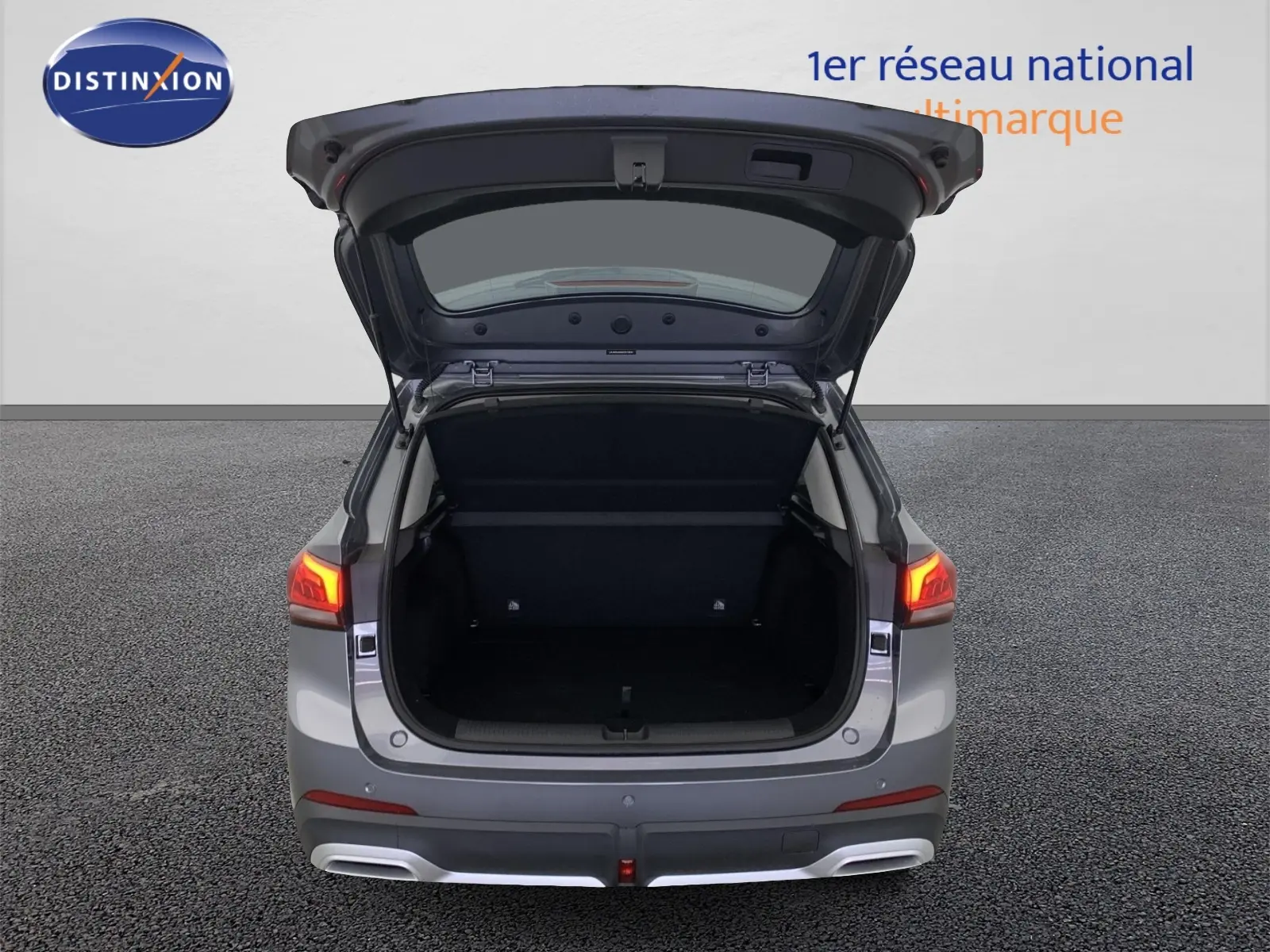 Vue arrière du MG ZS 1.5 L Hybrid+ gris Hampstead avec coffre ouvert et feux arrière allumés.