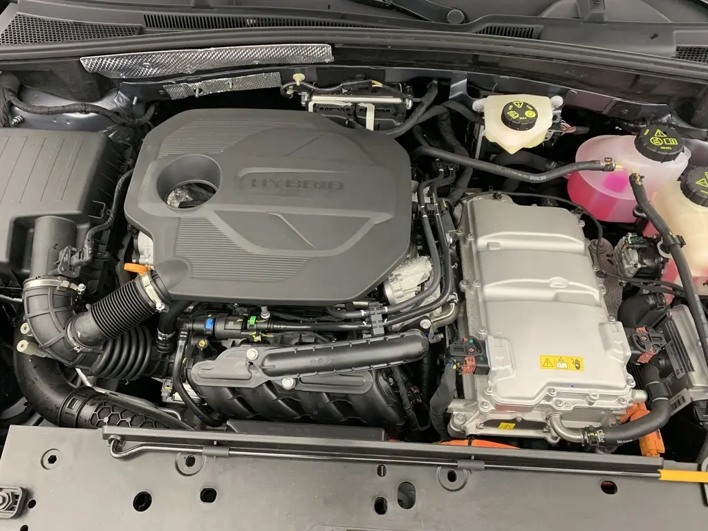 Vue rapprochée du moteur hybride du MG ZS 1.5 L Hybrid+ 197 ch, montrant le compartiment moteur propre et organisé.
