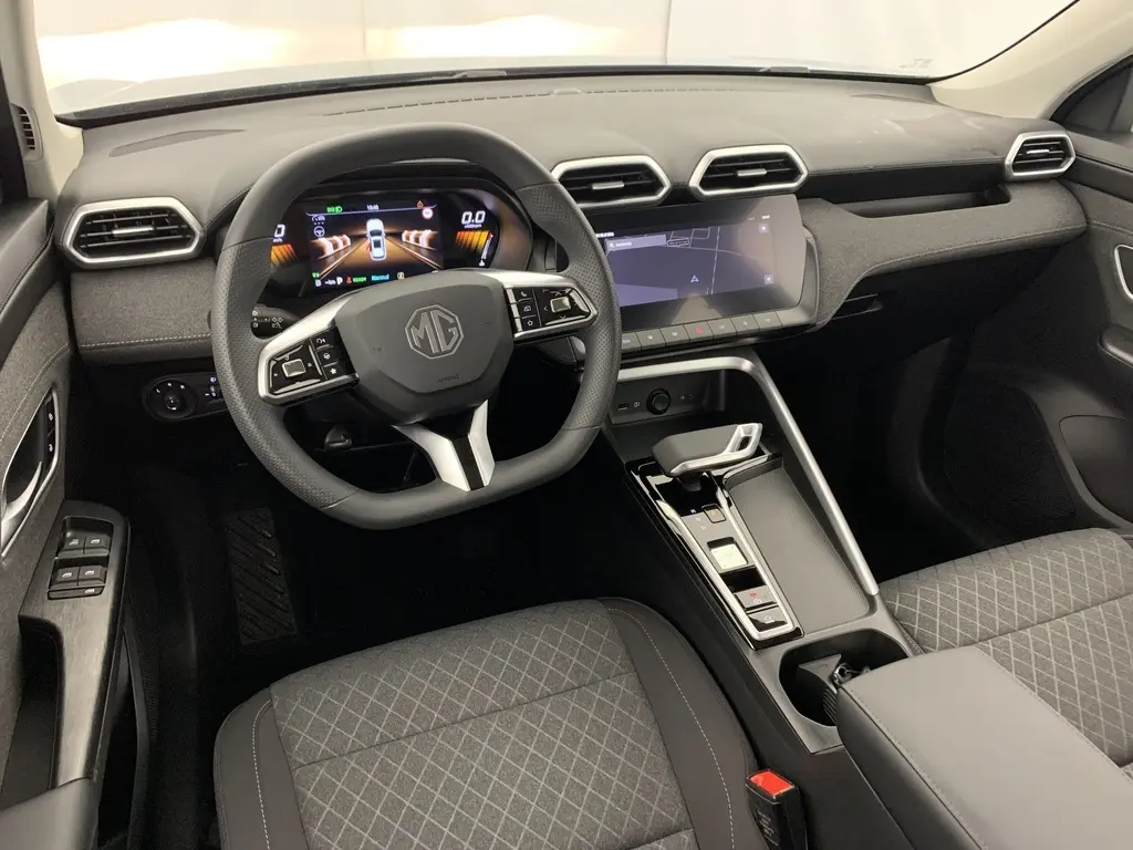 Vue intérieure avant du MG ZS 1.5 L Hybrid+ 2026 avec tableau de bord numérique et sièges tissu noir.