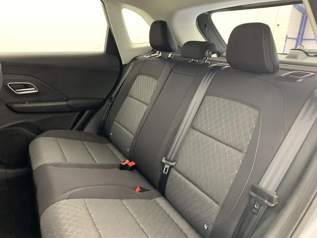 Vue intérieure arrière côté gauche des sièges en tissu noir et gris du MG ZS 1.5 L Hybrid+ 2026 avec ceintures de sécurité visibles.