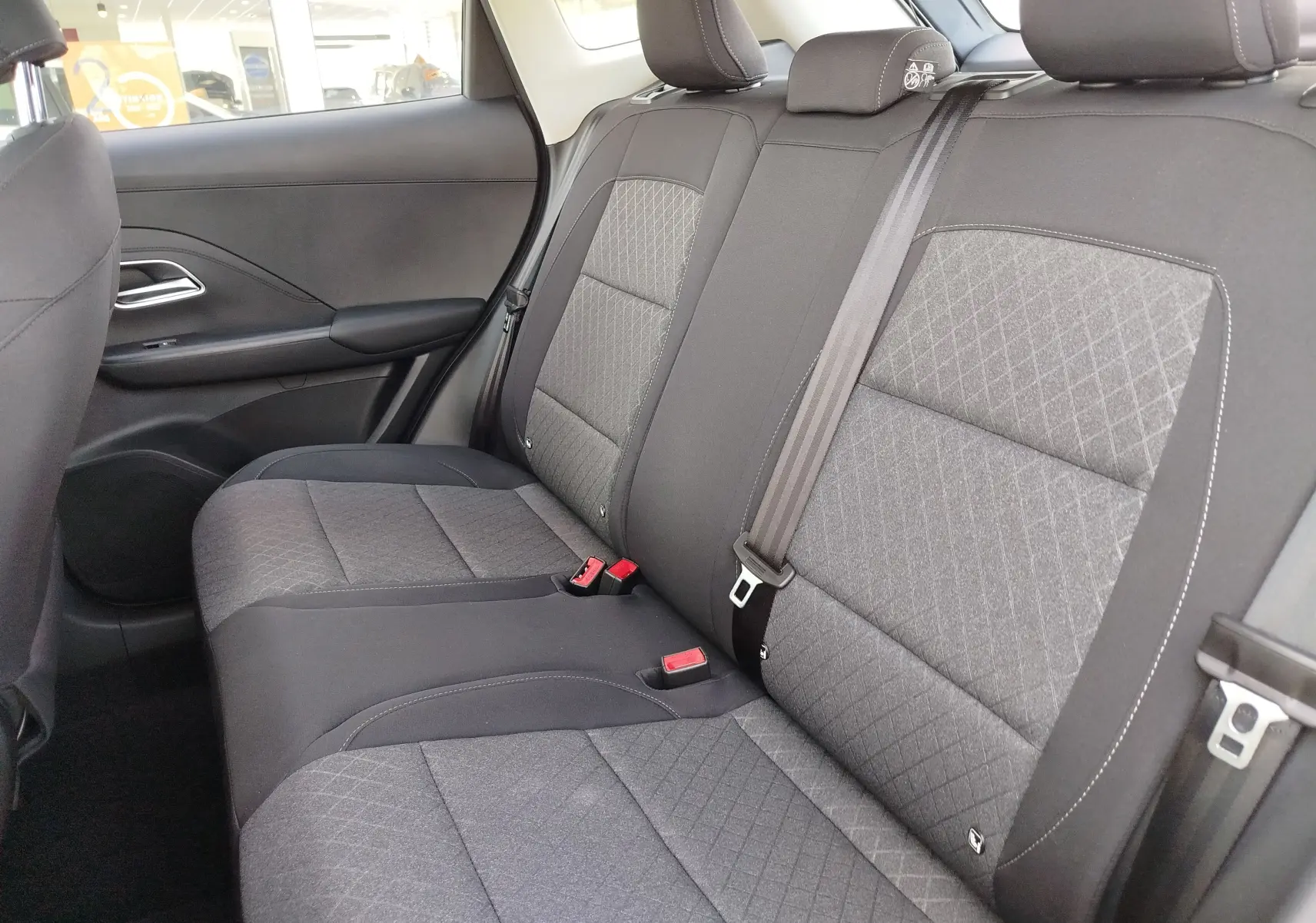 Vue intérieure côté droit des sièges arrière gris foncé avec motifs géométriques du MG ZS 1.5 L Hybrid+ 2026 en Hampstead Grey.