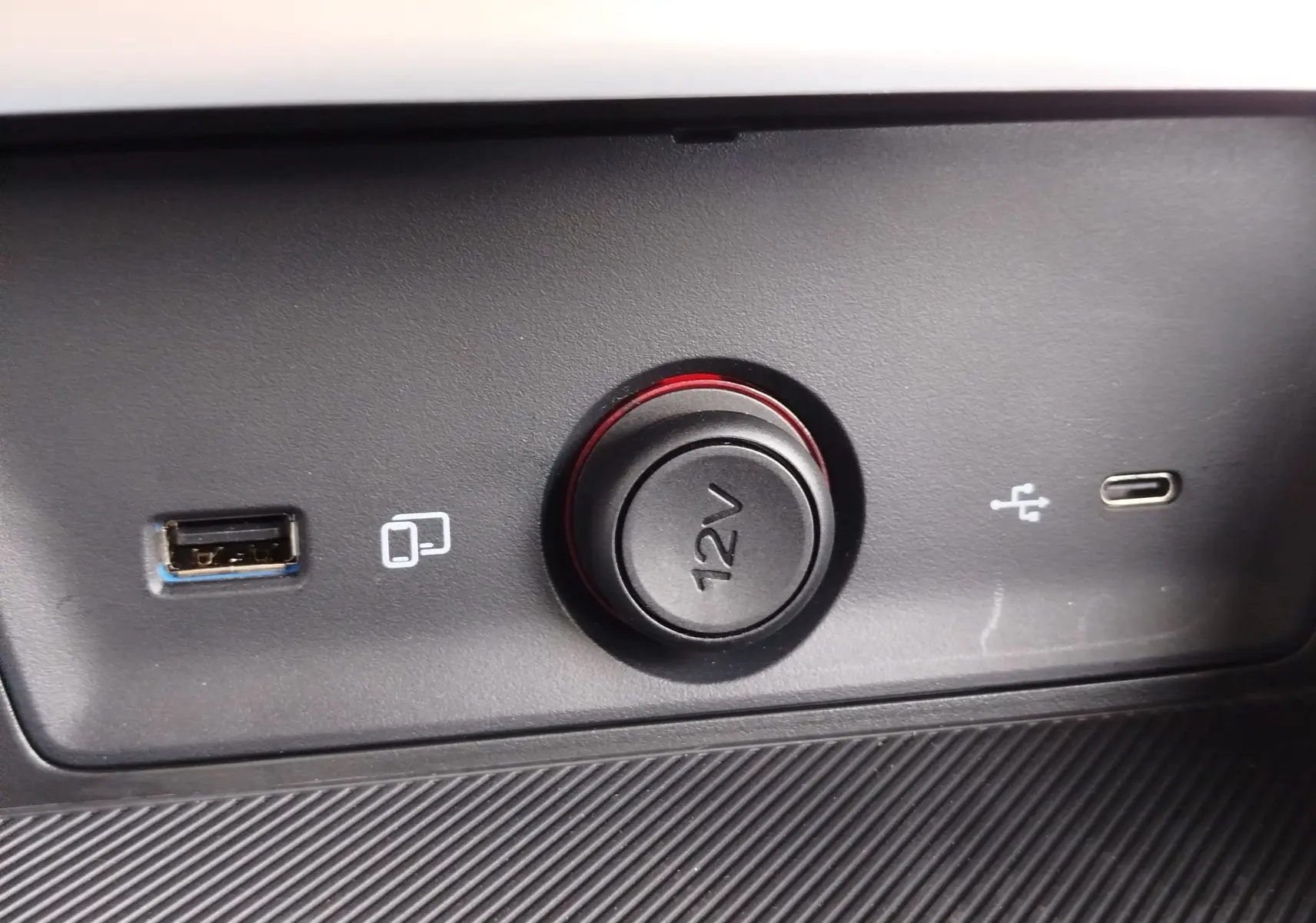 Prise 12V entourée de LED rouge avec ports USB-A et USB-C sur tableau de bord du MG ZS 1.5 L Hybrid+ Hampstead Grey.