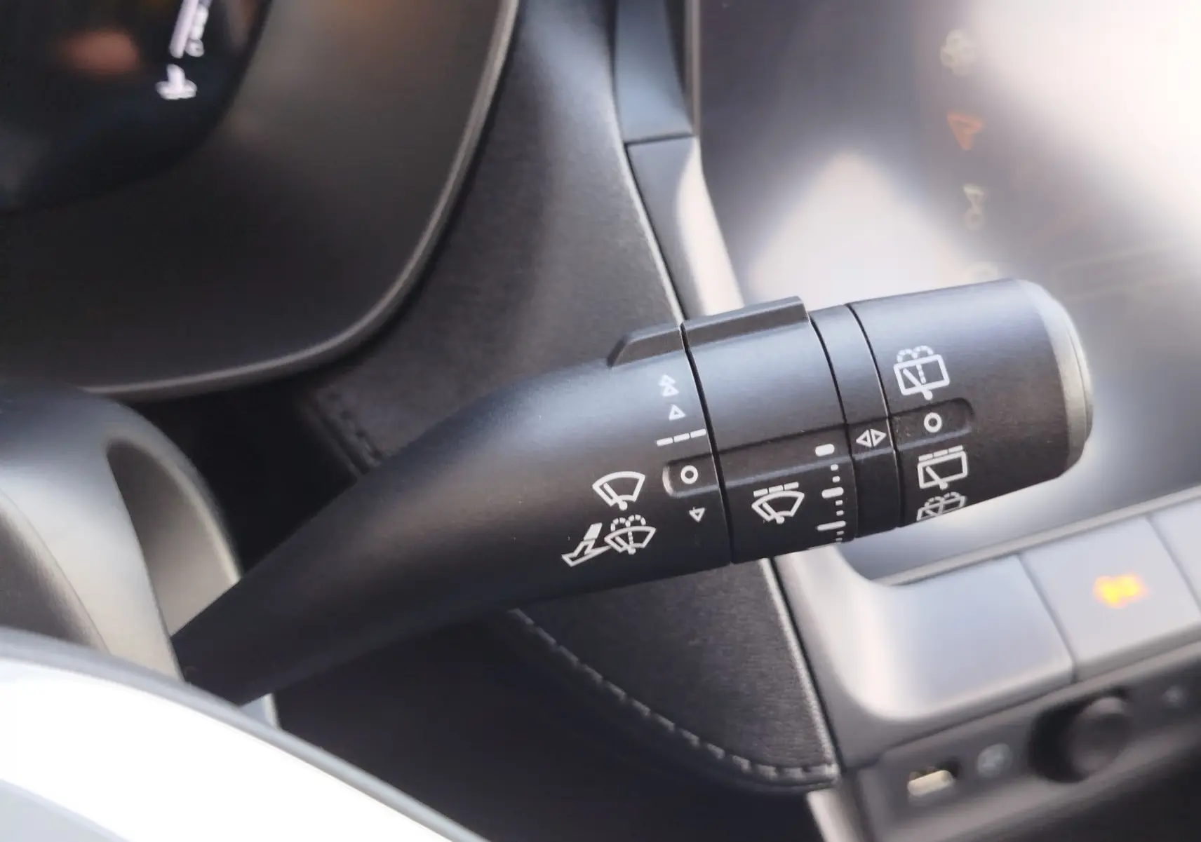 Gros plan sur la commande des essuie-glaces du MG ZS 1.5 L Hybrid+ 2026, intérieur noir avec détails fonctionnels blancs.