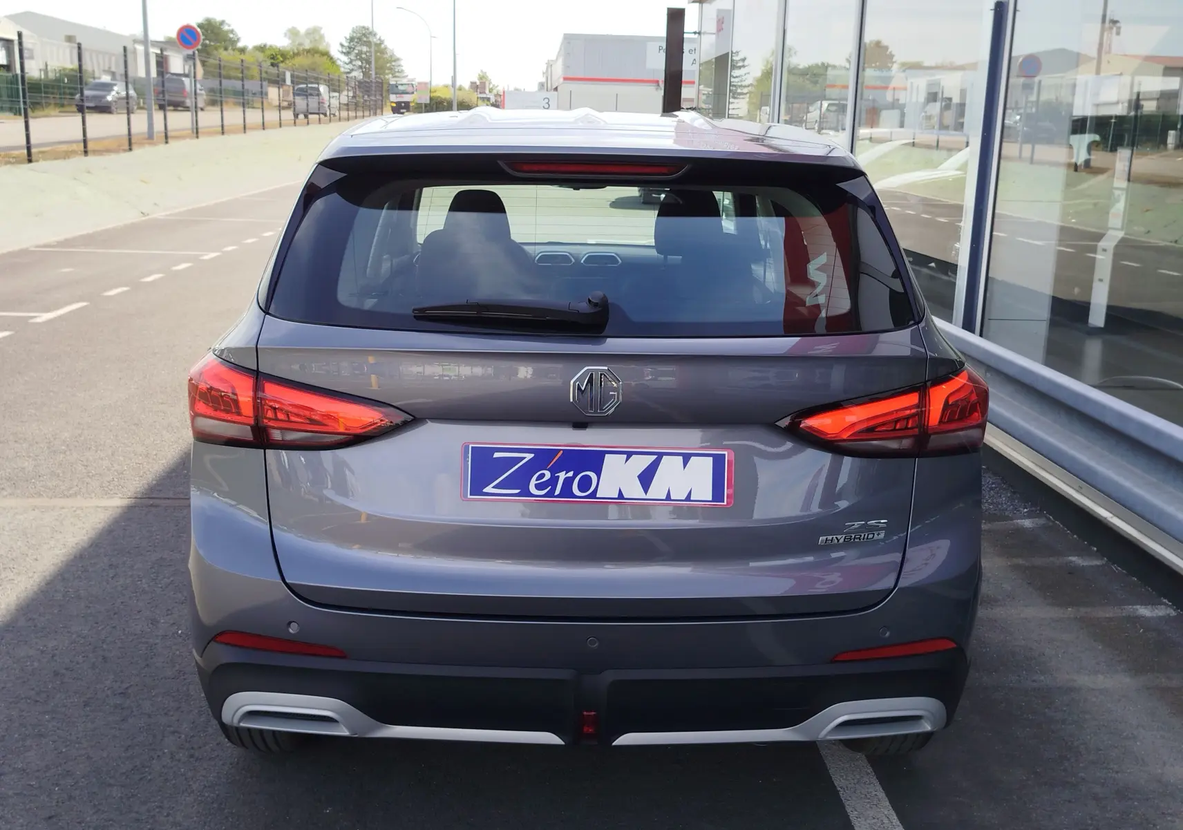 Vue arrière d'un MG ZS 1.5 L Hybrid+ 2026 en gris Hampstead, avec feux LED et logo MG bien visibles.