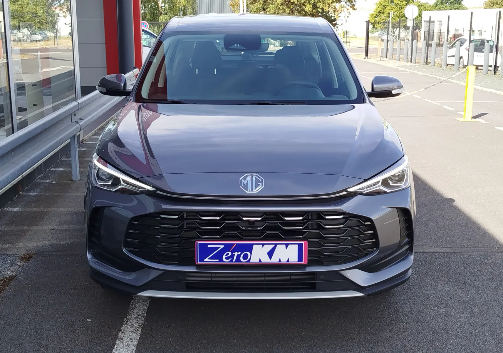 Vue de face du MG ZS 1.5 L Hybrid+ 2026 en gris Hampstead, avec calandre noire et phares LED fins.