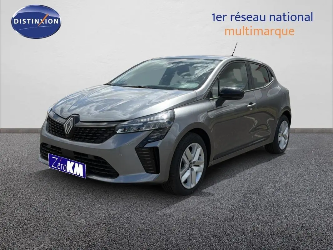 Renault Clio gris foncé vue 3/4 avant droit, avec calandre noire et jantes argentées sur sol gris.