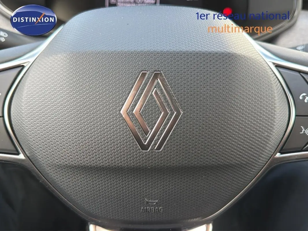 Gros plan sur le volant noir avec logo Renault de la Clio gris foncé, version 2026, montrant les commandes intégrées.