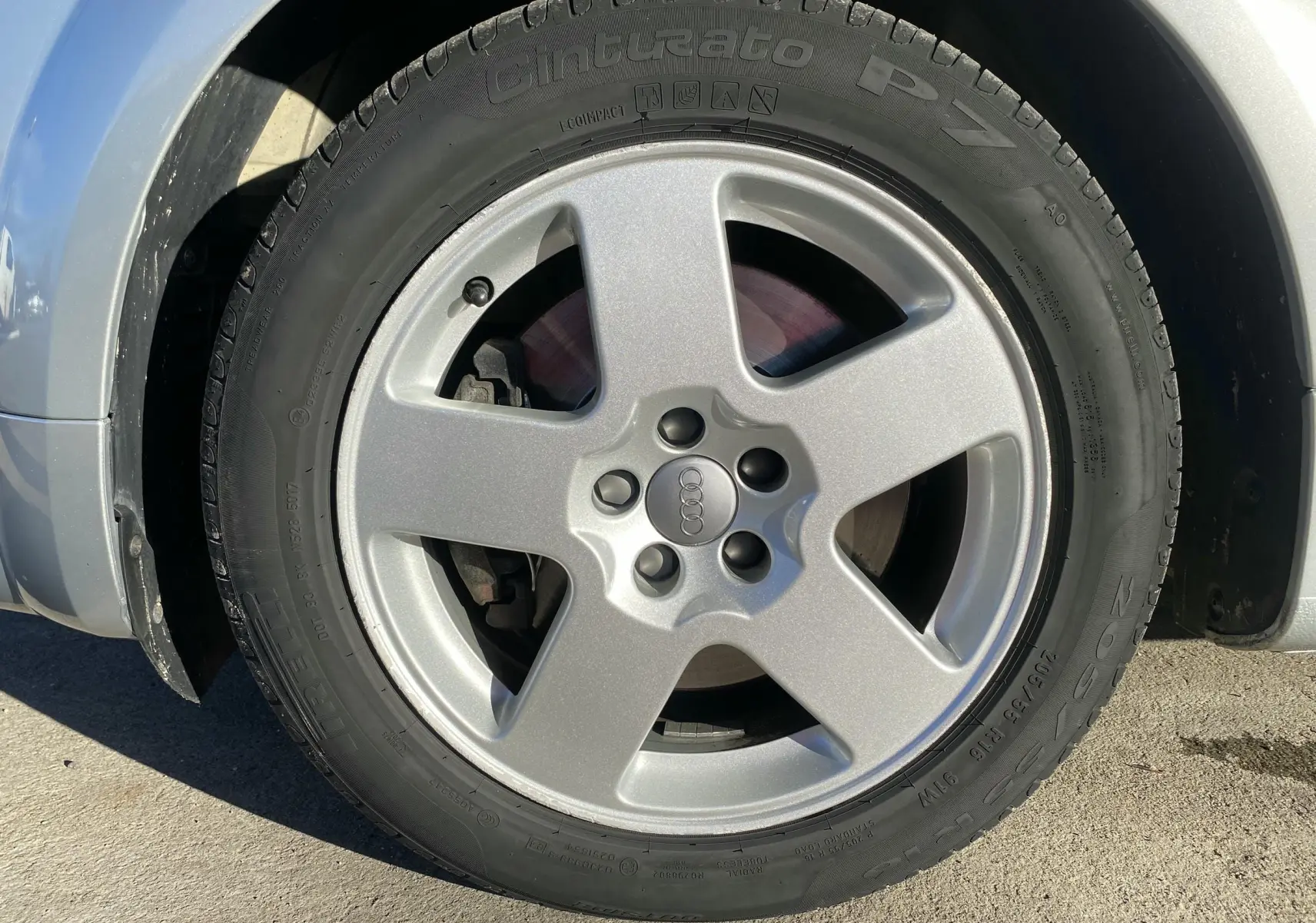 Gros plan sur la roue avant gauche grise de l'Audi TT Coupé (8N) avec jante alliage cinq branches.