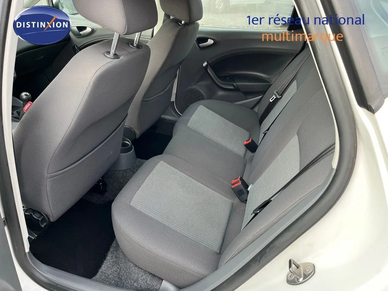 Vue intérieure arrière droite montrant les sièges arrière gris d'une SEAT Ibiza blanche 2010 1.6 TDI Style.