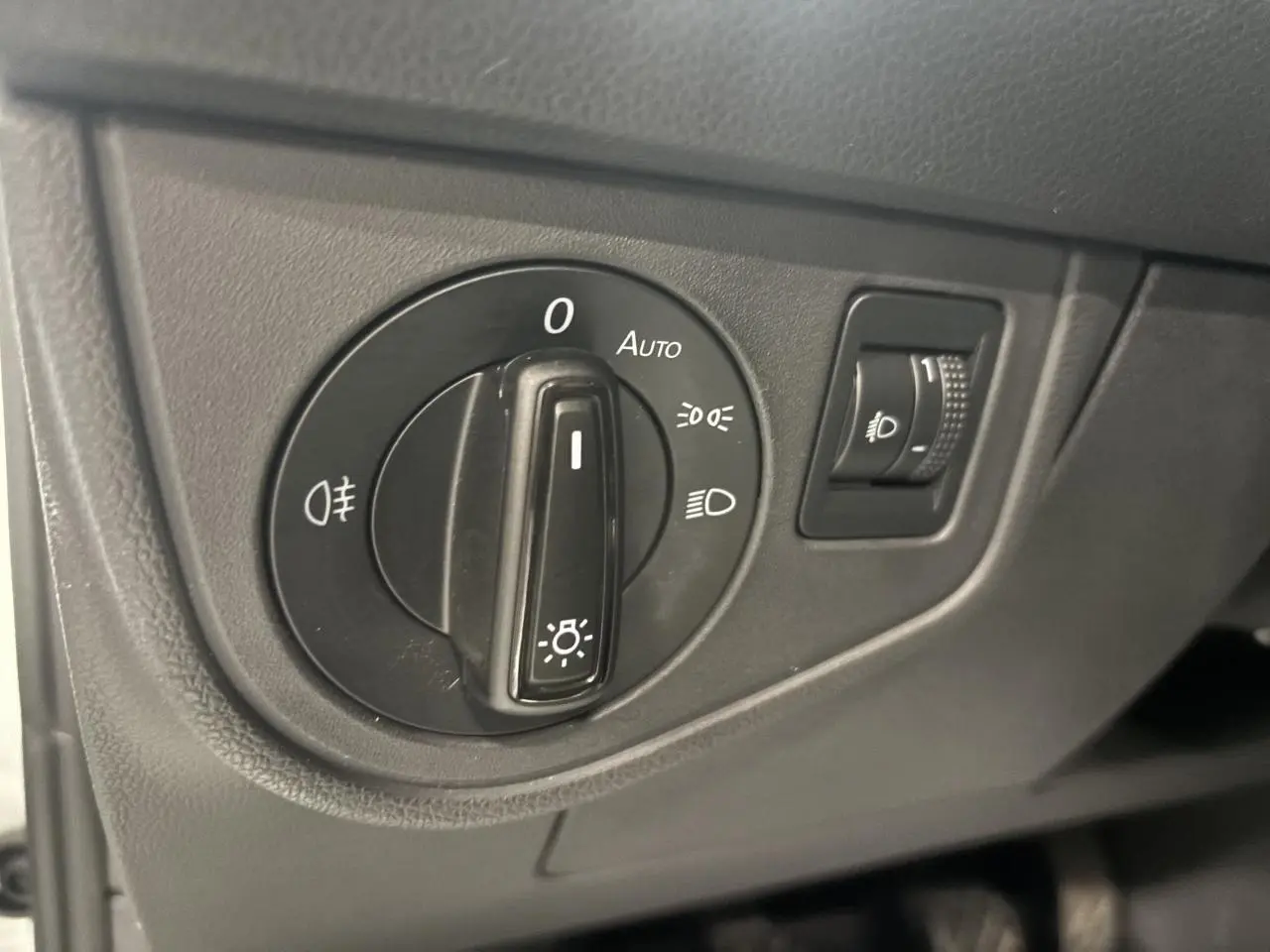 Gros plan sur le sélecteur de feux noir dans l'habitacle du Volkswagen Taigo blanc, version 2023.