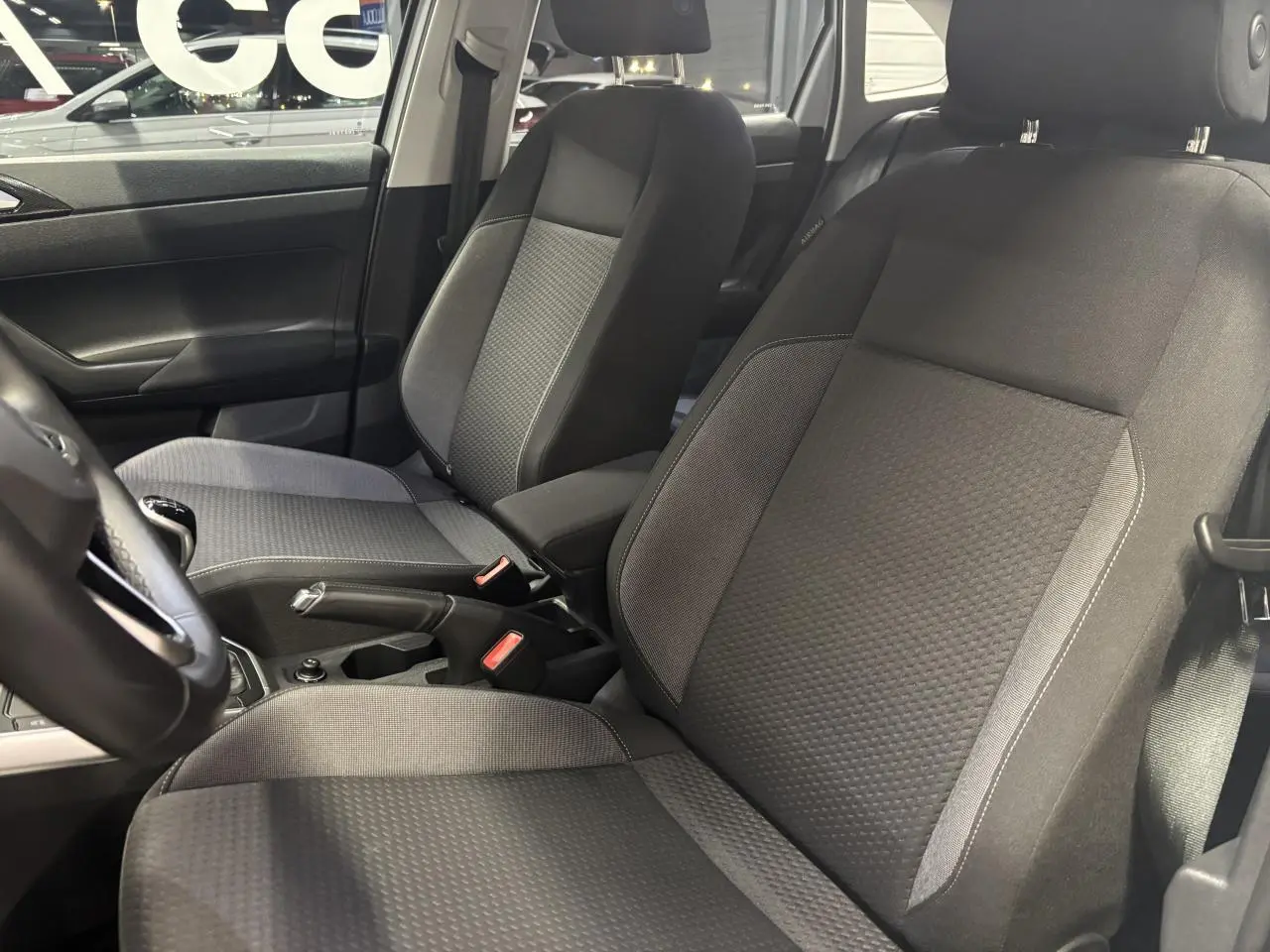 Vue intérieure côté gauche montrant les sièges avant en tissu gris du Volkswagen Taigo 1.0 TSI Life 2023.