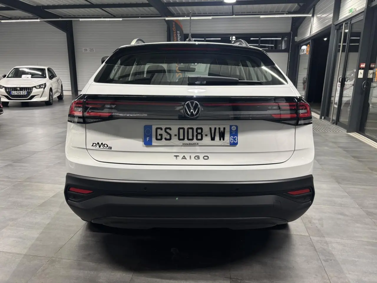 Vue arrière d’un Volkswagen Taigo blanc 2023 avec feux arrière horizontaux et plaque d’immatriculation française.