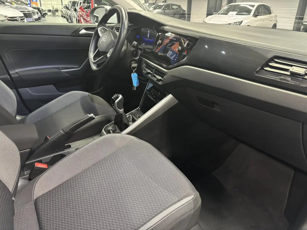 Intérieur avant droit du Volkswagen Taigo 2023, volant cuir multifonctions et tableau de bord avec écran tactile.