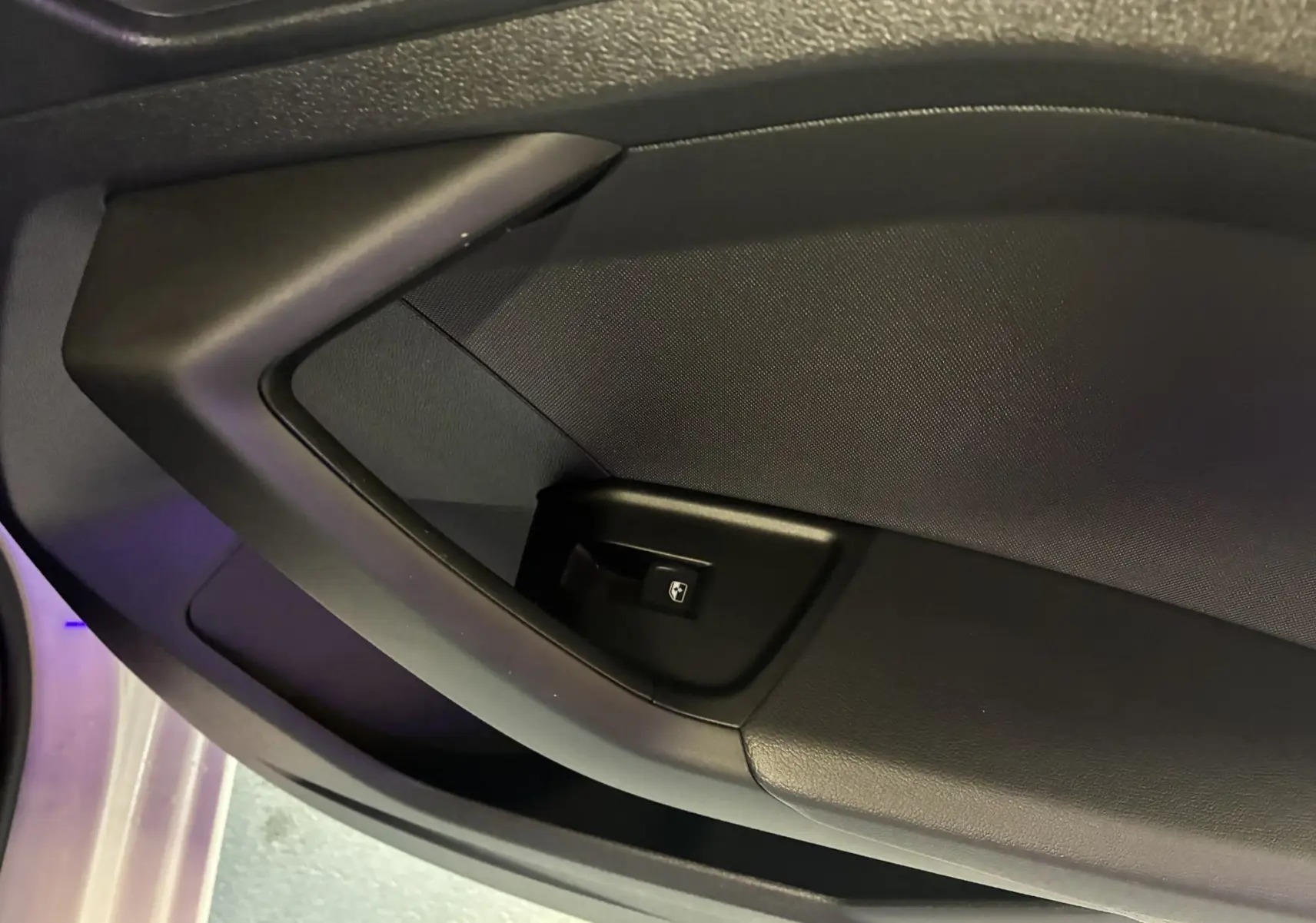 Gros plan sur la commande de lève-vitre côté conducteur de l'Audi A1 blanche, intérieur noir.