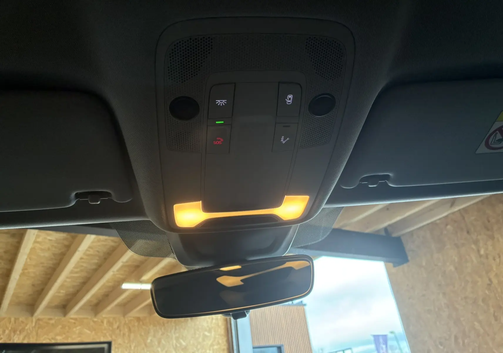 Vue intérieure du plafonnier et rétroviseur d'une Audi A1 blanche, avec éclairage intérieur allumé.