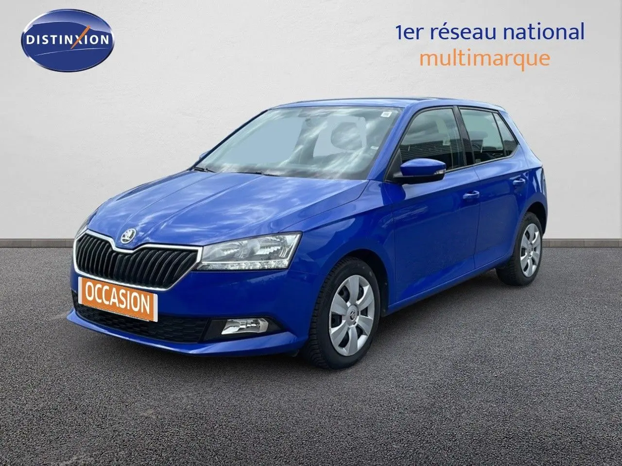 SKODA Fabia 1.0 TSI bleu énergie vue 3/4 avant droit sur fond neutre avec plaque "OCCASION" orange.