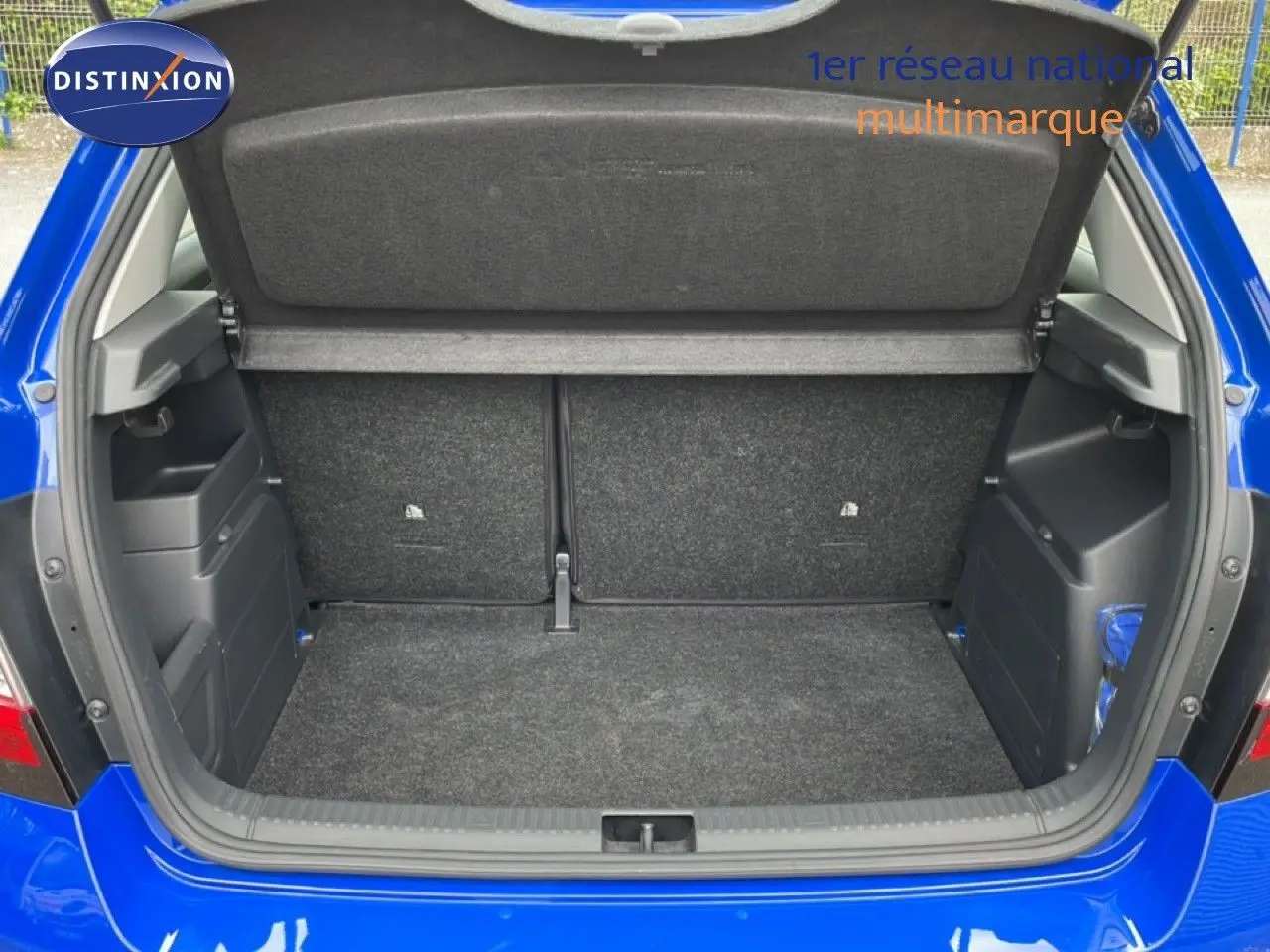 Coffre ouvert vu de l'arrière d'une Skoda Fabia 1.0 TSI 95CH Active bleu énergie, montrant l'espace de chargement vide.