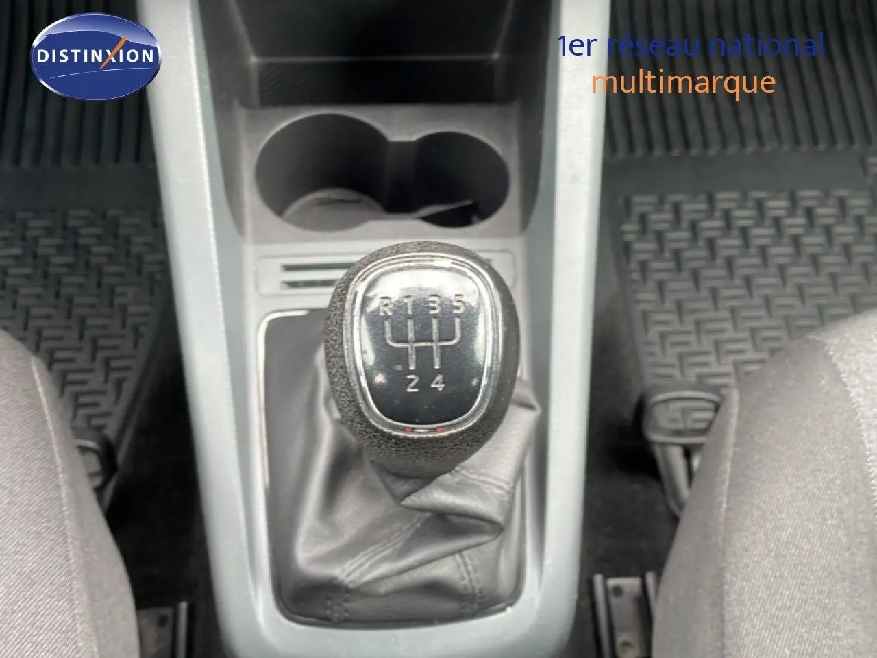 Gros plan sur le levier de vitesses manuel de la Skoda Fabia bleu énergie, avec console centrale et tapis noirs visibles.