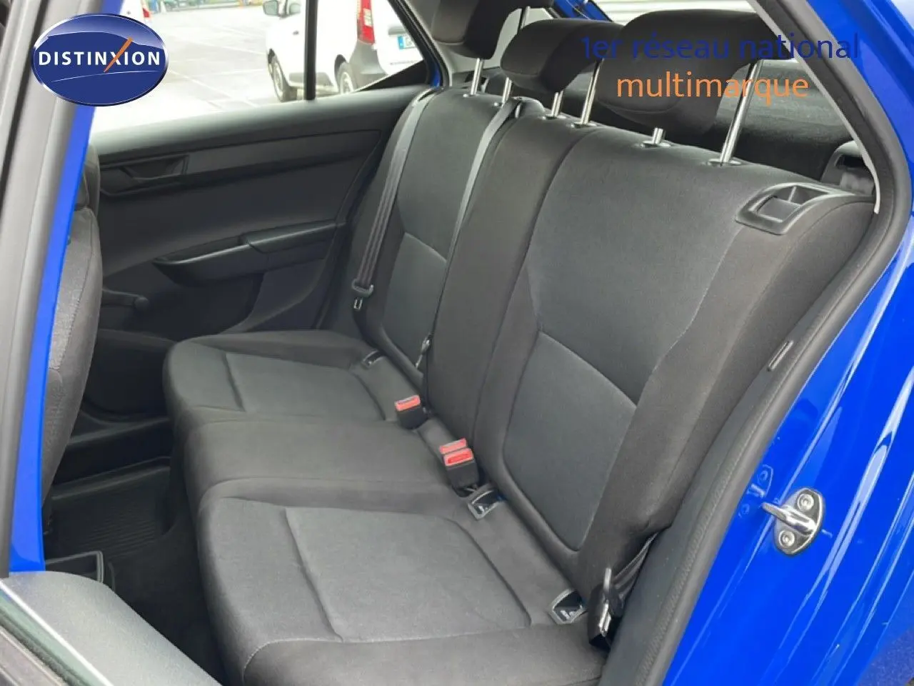 Vue intérieure côté gauche des sièges arrière en tissu noir d'une Skoda Fabia 2019 bleu énergie avec porte ouverte.