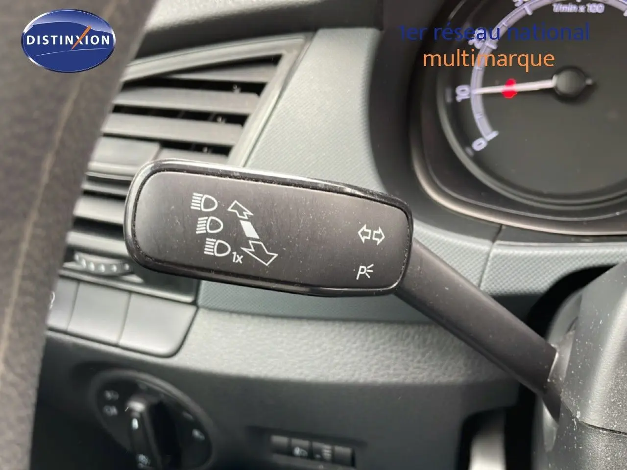Gros plan sur la commande des clignotants et feux d’une Skoda Fabia 2019, intérieur noir avec tableau de bord partiel.