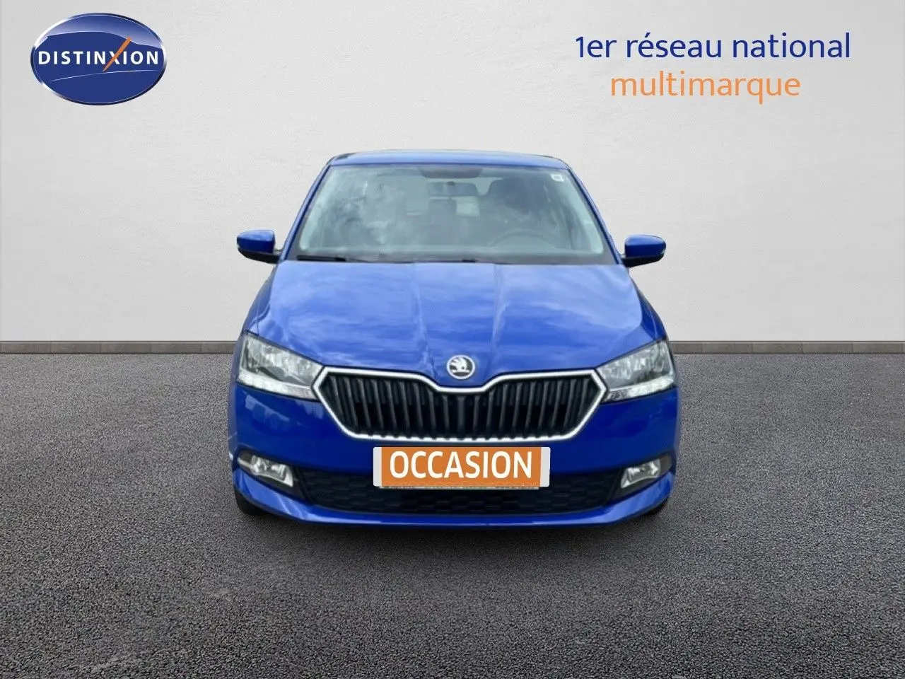 Vue frontale d'une Skoda Fabia 1.0 TSI Active bleu énergie avec plaque "OCCASION" sur fond neutre.
