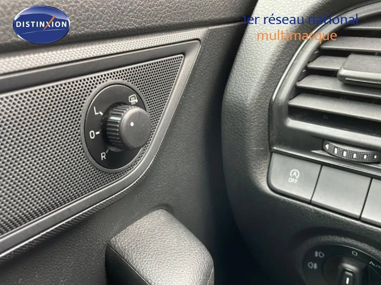 Gros plan sur le réglage des rétroviseurs côté gauche et la ventilation intérieure noire d'une Skoda Fabia bleu énergie.