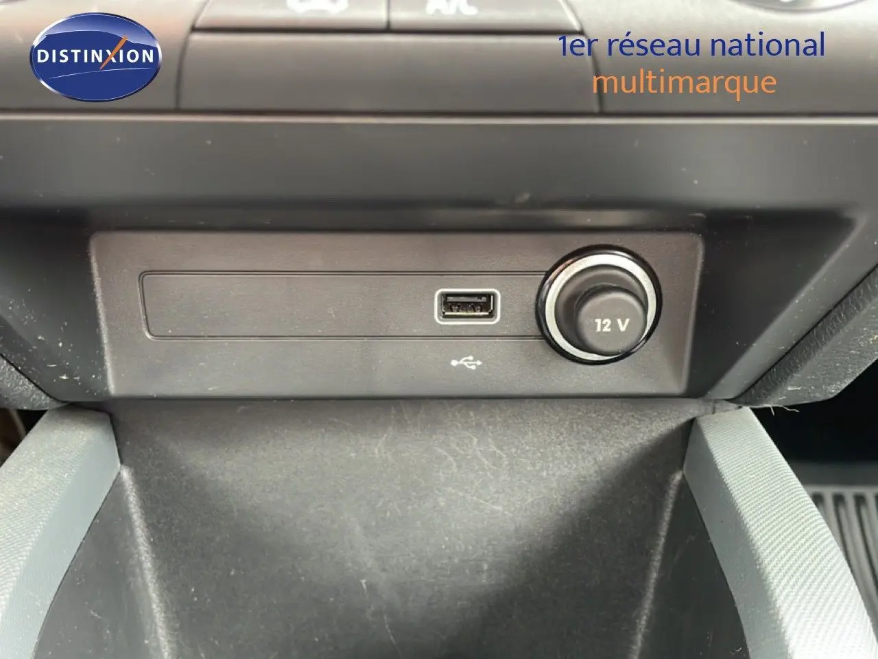 Vue rapprochée de la console centrale d’une Skoda Fabia 2019, montrant une prise USB et un allume-cigare 12V.