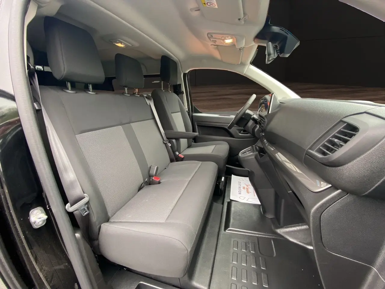Intérieur de l'Opel Vivaro noir, vue côté gauche sur les sièges avant et tableau de bord moderne.