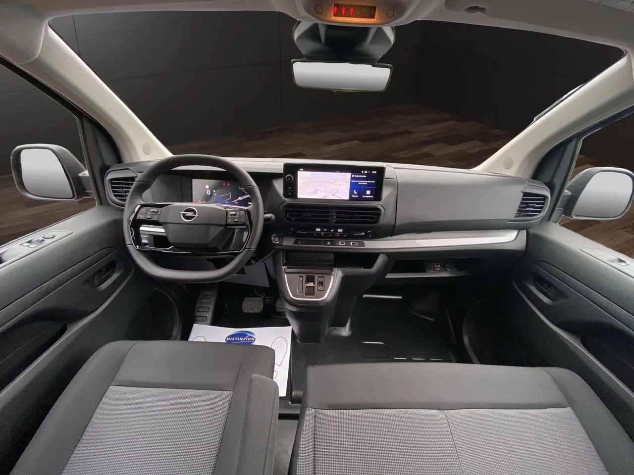 Intérieur noir de l'Opel Vivaro 2025 vu de face, avec tableau de bord moderne et écran tactile central.