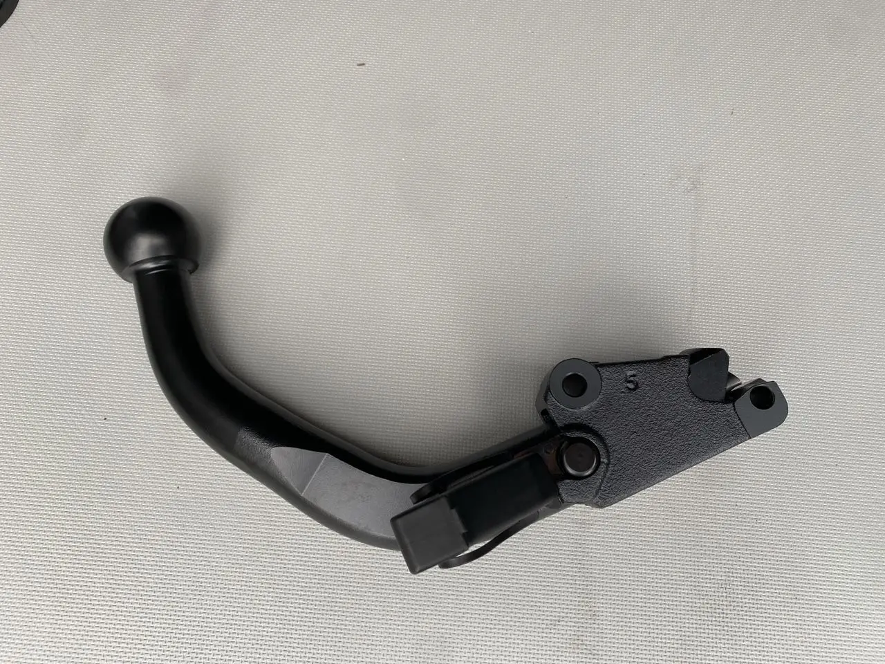 Gros plan sur un attelage noir monobloc démontable pour Opel Vivaro 2025, avec mécanisme de fixation visible.