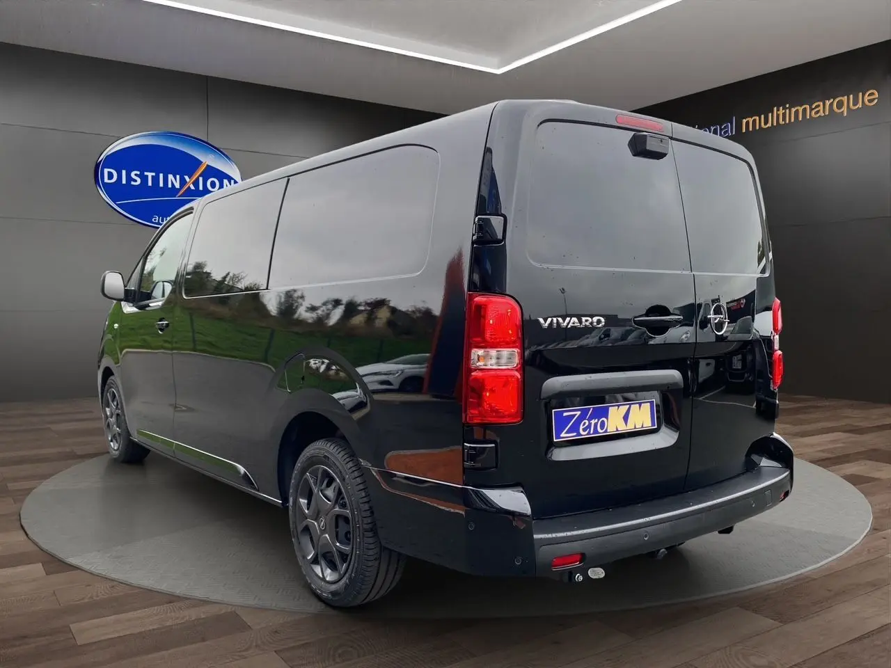 Vue 3/4 arrière droite d’un Opel Vivaro noir 2025 avec attelage et jantes noires en showroom.